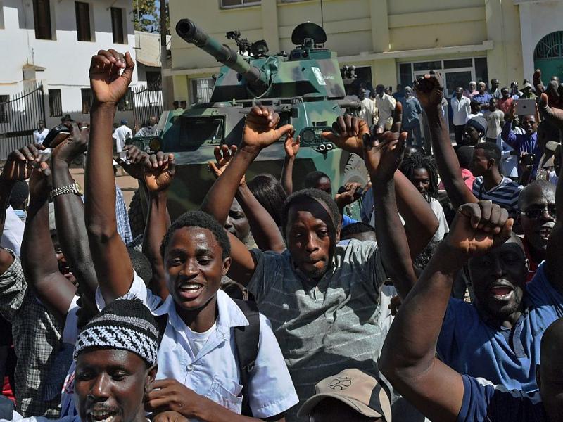 Gambians celebrate the departure of former strongman Yahya Jammeh in front of an armoured vehicle manned by West African troops in early 2017. Carl de Souza/AFP via Getty Images
