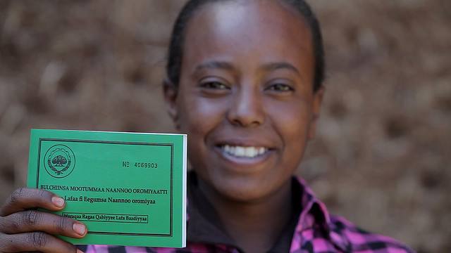Asilya Gemmal displays her land certificate, given by the Ethiopian government, with USAID assistance.