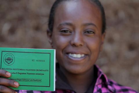 Asilya Gemmal displays her land certificate, given by the Ethiopian government, with USAID assistance.