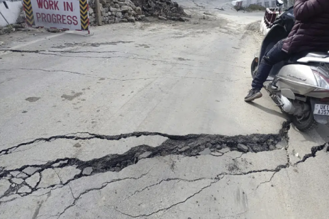 A motorist navigates his way through a crack on a road in Joshimath, India