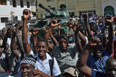 Gambians celebrate the departure of former strongman Yahya Jammeh in front of an armoured vehicle manned by West African troops in early 2017. Carl de Souza/AFP via Getty Images