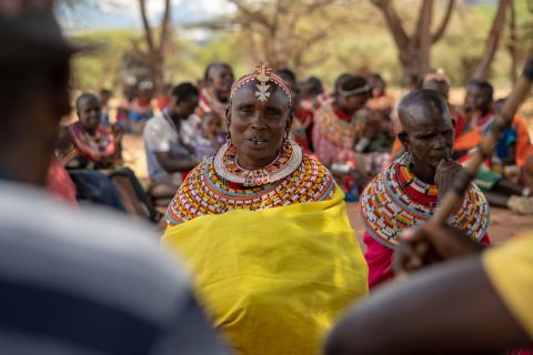 A woman speaks about land rights during a community meeting