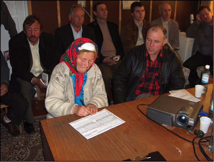 Landowner signing land consolidation agreement form in Moldova